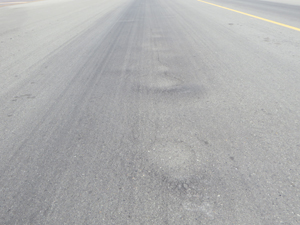 Overview photo (shot in the longitudinal direction) showing five or six corrugations. Signs of water ponding is visible at each corrugation location.