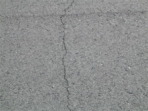 Close-up photo of a single low-severity crack. The crack is tight and has no visible spalling.