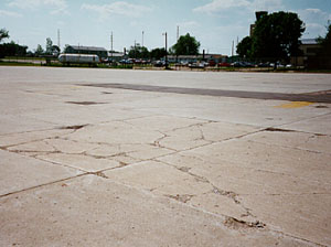 Overview photo showing a slab that is broken into more than five pieces.           The cracks that divide the pieces are a combination of medium- and high-severity cracks.