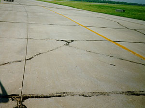 Overview photo showing a slab that is broken into four or five larger pieces.           The cracks that divide the pieces are low-severity cracks.